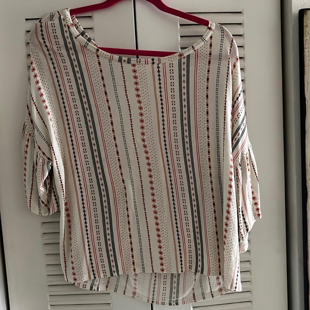 Large hangaround shirt.white background with stripes going down the shirt.